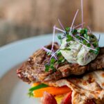 A delicious grilled steak with herb butter, served with assorted vegetables on a plate.